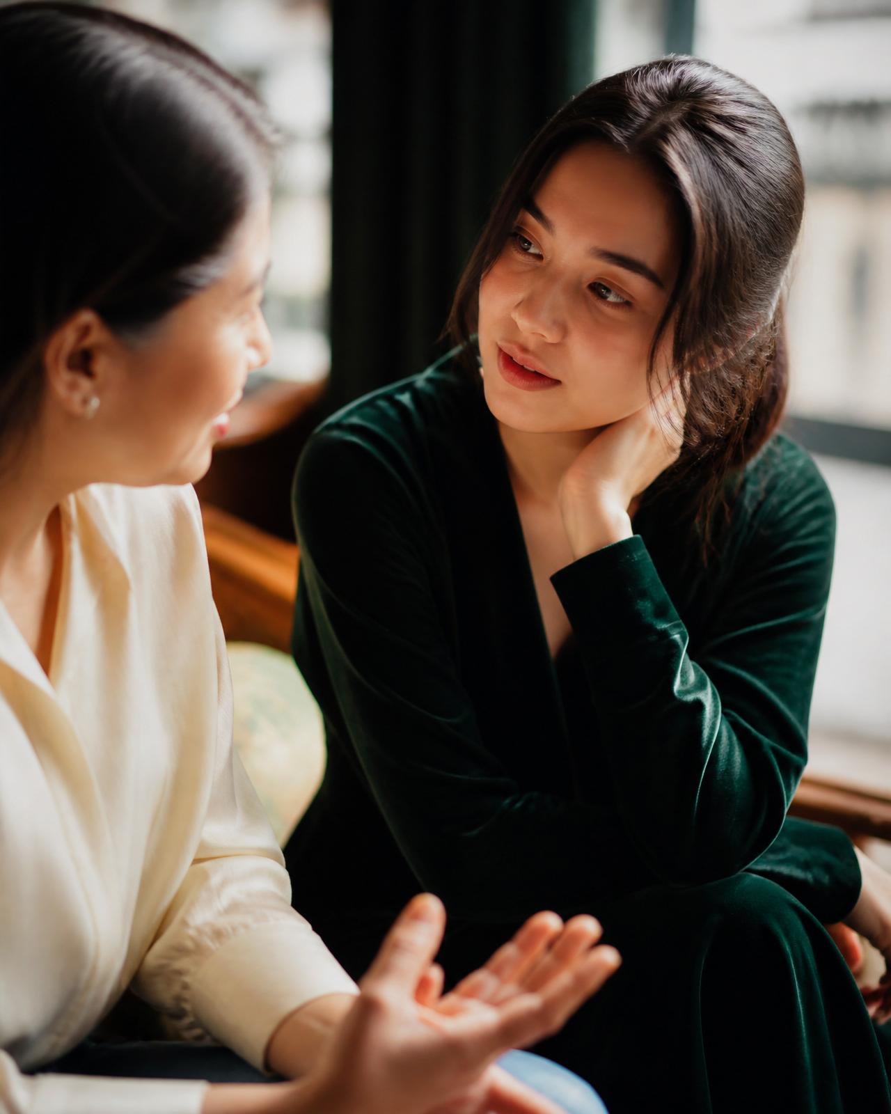 A quiet, attentive conversation between two people in warm window light